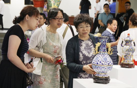 首届中国珐琅艺术展(图3) 观展者在认真鉴赏珐琅艺术品